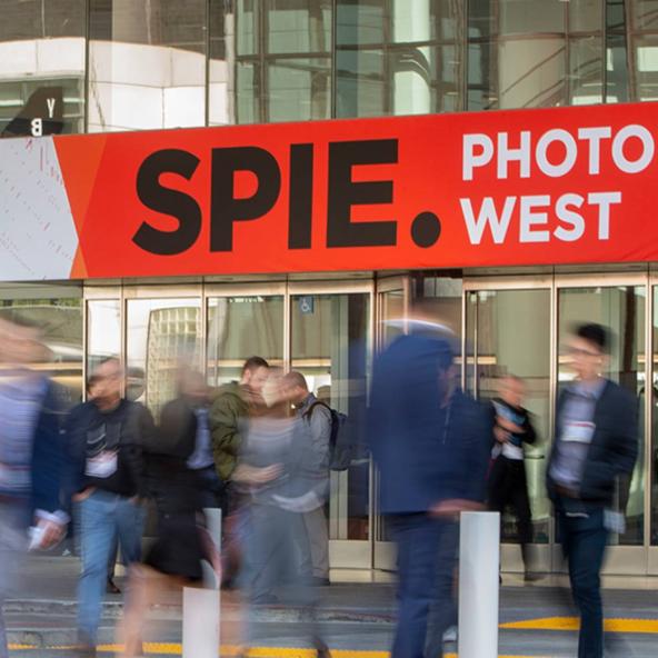 blurry photo of people crossing the street to enter SPIE Photonics West event